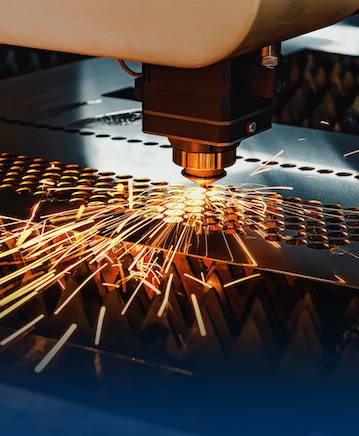 CNC laser cutting sparks across sheet metal